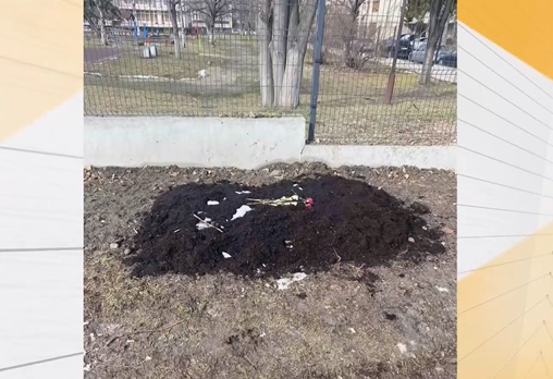 Гроб с импровизиран кръст и положени цветя върху него ежедневно