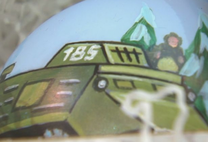 Коледни играчки изрисувани с картинки с военна техника са изложени