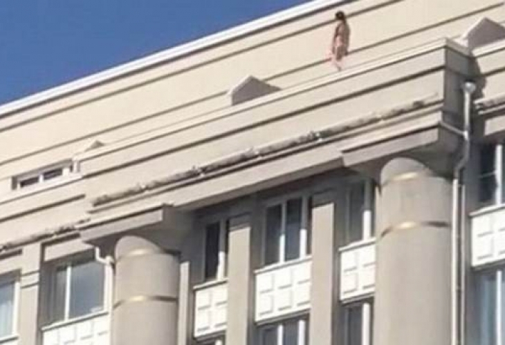 Гола жена се разходи по покрива на сграда посред бял