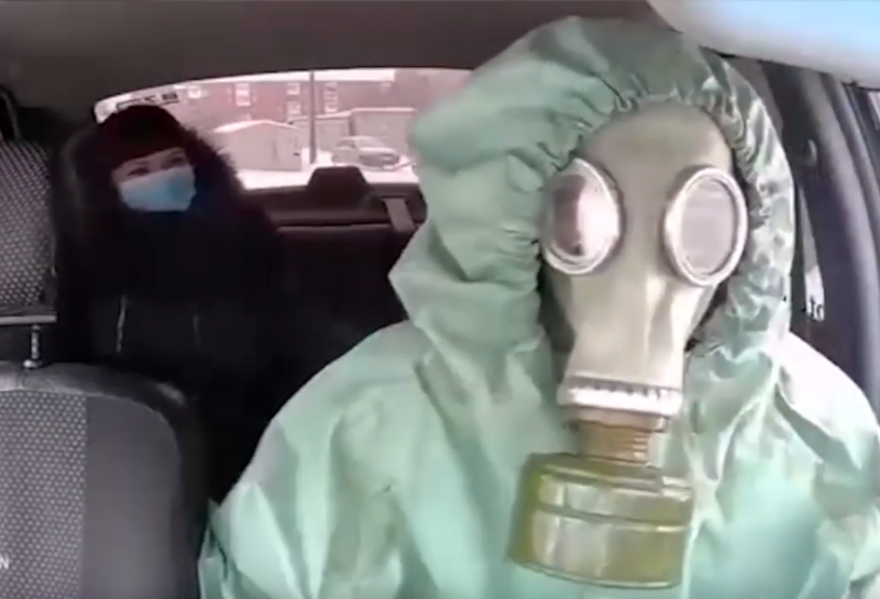 Таксиметров шофьор вози клиенти с противогаз и защитен костюм срещу ...