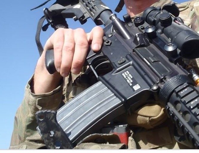 Лагерниците някои облечени в бойни униформи внимателно насочват пушките си