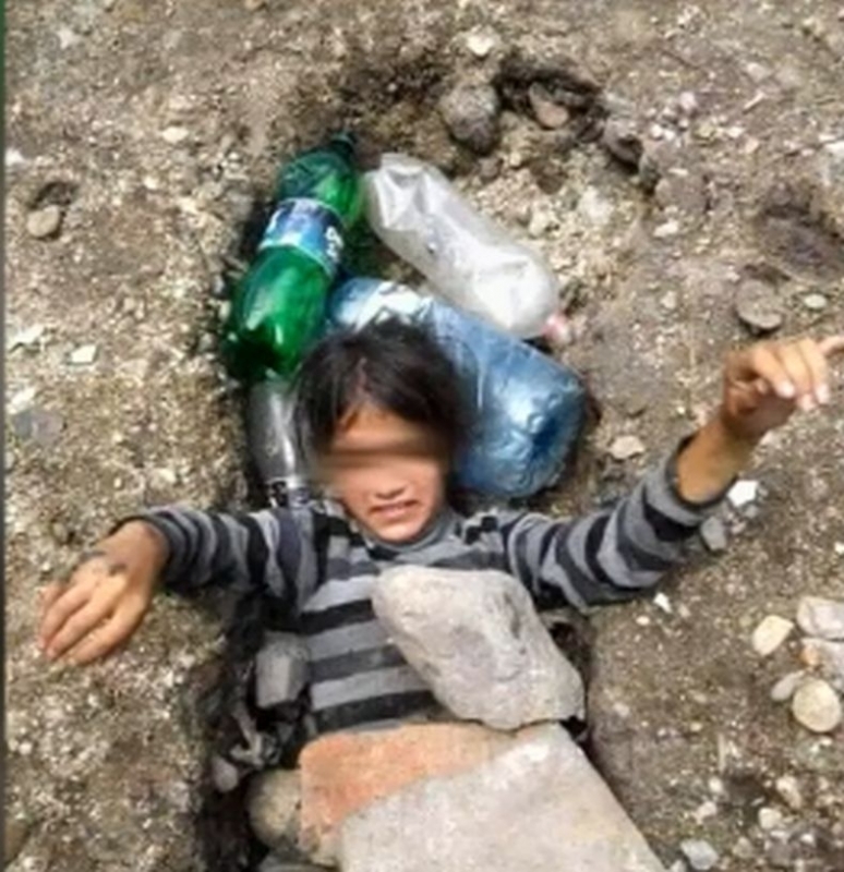 Снимка на ромско дете затрупано с камъни и бутилки оставено
