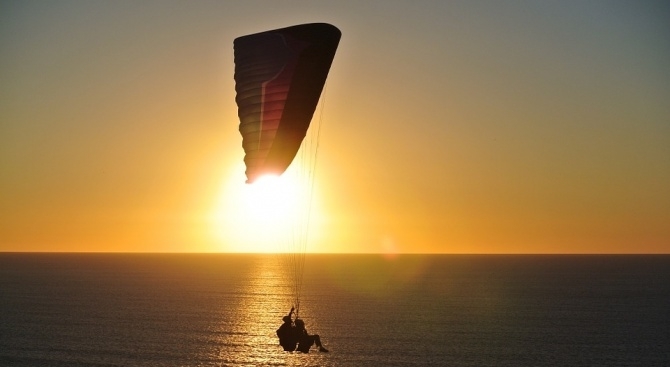 Двама туристи издигнати с парашут над морето на плаж Каваци